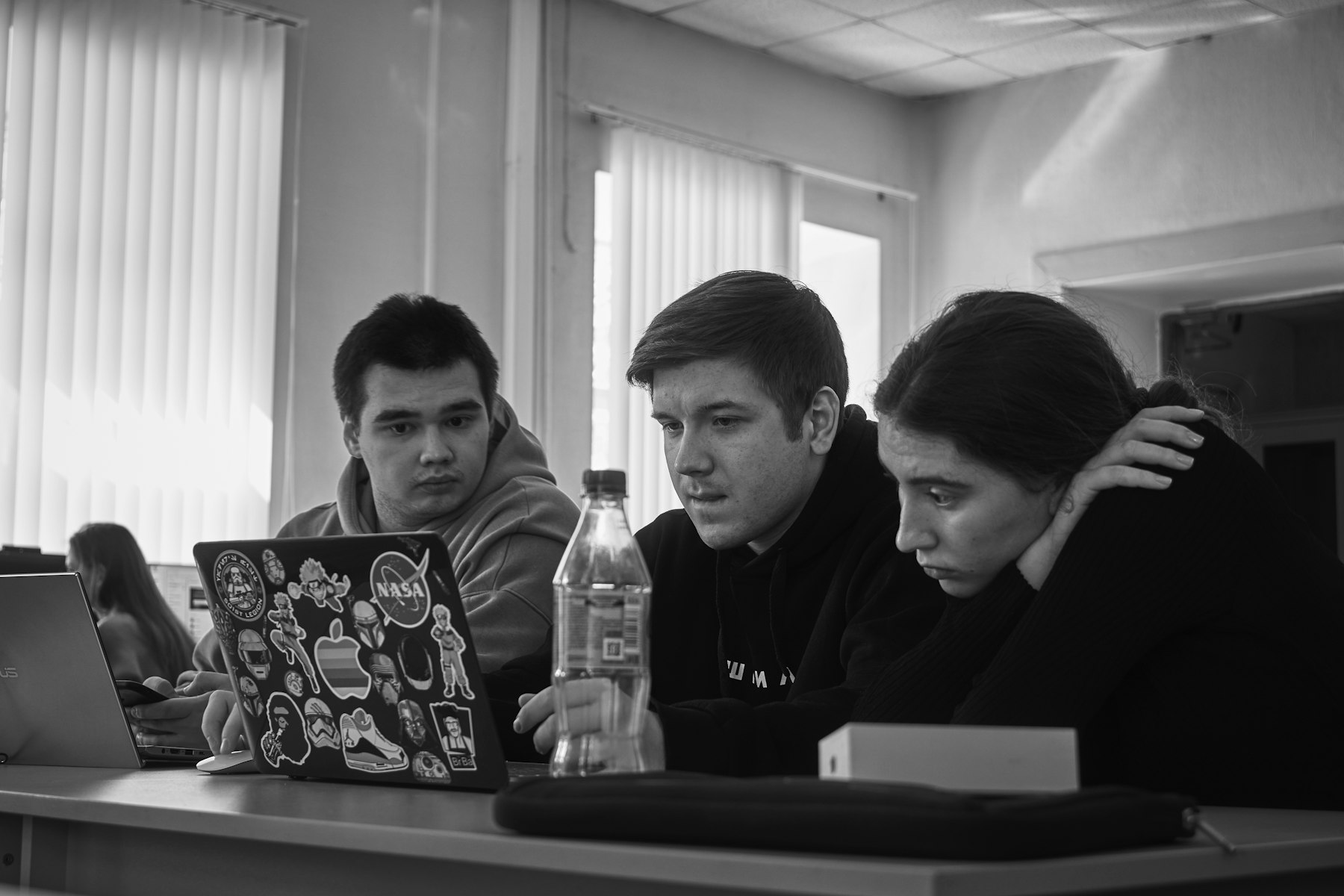 Three young founders reviewing work on a laptop